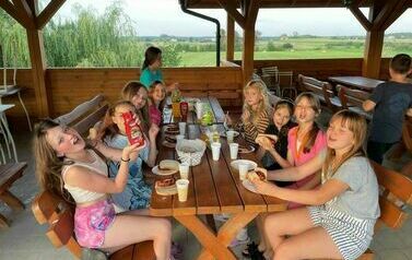 Dziewczynki jedzą kiełbaski z grila