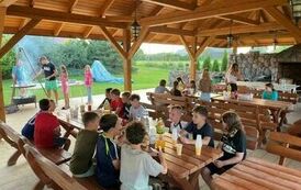Dzieci siedzą przy stołach na grilu