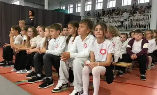 dzieci w strojach galowych z kotylionami
